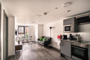 a kitchen and living room with a couch and a table at Smart 1 Bedroom Apartment in Liverpool Centre in Liverpool