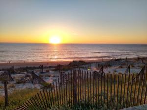 プライア・デ・ミラにあるCasa da Praiaの塀と海を挟んだ海岸の夕日