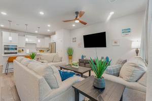 a living room with two couches and a flat screen tv at Stylish Barefoot Townhome, Sleeps 10 NEW! in Myrtle Beach