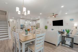 a kitchen and living room with a table and a couch at Stylish Barefoot Townhome, Sleeps 10 NEW! in Myrtle Beach