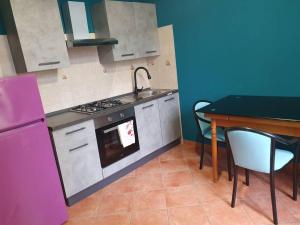 uma cozinha com uma mesa, um lavatório e um fogão em Nel Cuore Pulsante della Città! em Alessandria