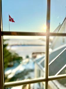 ein Fenster mit Blick auf eine Straße und eine Flagge in der Unterkunft Cozy Rooms at Organic Vinery, Vesterhave Vingaard - see more at BY-BJERG COM in Karrebæksminde