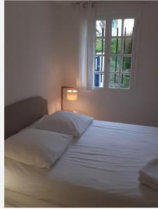 - une chambre avec un lit blanc et une fenêtre dans l'établissement Mendiska, à Bayonne