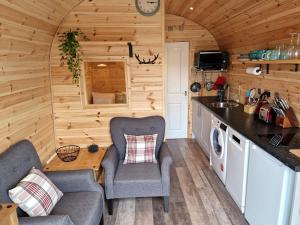 uma cozinha e sala de estar numa pequena casa em Rowan Gorgeous Glamping Hideaway em Durnamuck