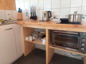 a kitchen with a wooden counter with a microwave at Refugio del Archipielago in Punta de Choros