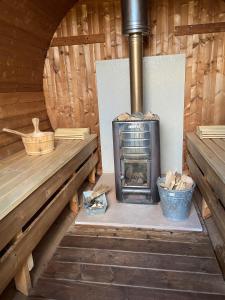 una estufa de leña en una cabaña de madera en Pipowagen op Camperplaats Vechtdal, en Nieuwleusen