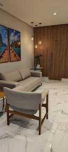 uma sala de estar com um sofá e uma mesa em Lindo apartamento em Guarapari - Novinho - Vista Maravilhosa em Guarapari