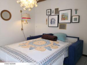 a bed in a room with a blue chair with a blanket on it at Ferienwohnung im alten Milchladen in Oberndorf