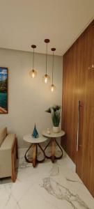 a living room with a table and a wooden door at Lindo apartamento em Guarapari - Novinho - Vista Maravilhosa in Guarapari