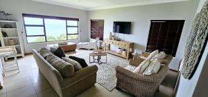 sala de estar con 2 sofás y TV en Ankervas, en Morganʼs Bay
