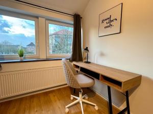 a desk in a room with a chair and a window at Modernes City Apartment nahe Hbf in Emden