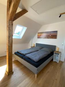 a bedroom with a bed in a room with a window at Modernes City Apartment nahe Hbf in Emden