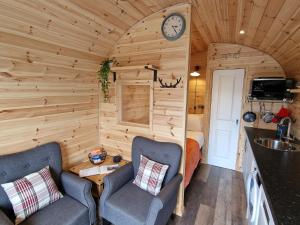 um quarto com duas cadeiras e um lavatório numa pequena casa em Rowan Gorgeous Glamping Hideaway em Durnamuck