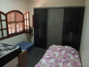 1 dormitorio con 1 cama, armario y ventana en Casa de praia em Cabo Frio até 12 hospedes, en Cabo Frío