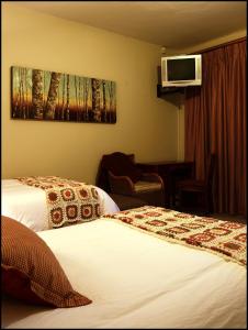 a hotel room with two beds and a tv on the wall at UnionView in Pretoria