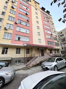 a building with cars parked in front of it at Hyat apartment in Bishkek