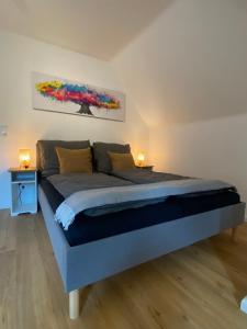 a large bed in a room with two lamps on tables at Modernes City Apartment nahe Hbf in Emden