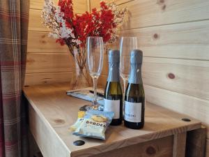 two bottles of wine and glasses on a table at Rowan Gorgeous Glamping Hideaway in Durnamuck