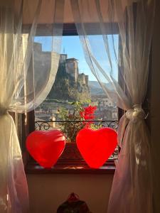 two hearts on a window with a view of a city at Il Borgo in Subiaco