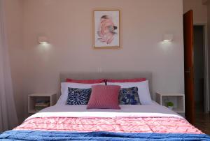 Schlafzimmer mit einem Bett mit einer rosa und blauen Bettdecke in der Unterkunft To Spitaki Dalamanara in Dhalamanára