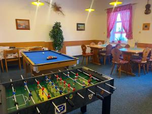 a room with a pool table and tables and chairs at Penzion Pod Ždánovem in Nezdice