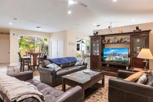 a living room with a couch and a tv at Tropical Oasis with Heated Pool in Boynton Beach
