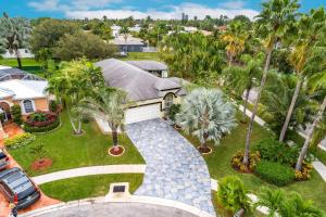 an aerial view of a house with palm trees and a driveway at Tropical Oasis with Heated Pool in Boynton Beach