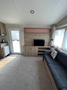 uma sala de estar com um sofá e uma televisão de ecrã plano em Lovely 2-Bed Luxury Caravan in Newquay em Newquay