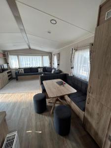 uma sala de estar com um sofá e uma mesa em Lovely 2-Bed Luxury Caravan in Newquay em Newquay