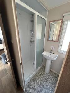 uma casa de banho com um chuveiro e um lavatório. em Lovely 2-Bed Luxury Caravan in Newquay em Newquay