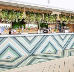 a colorful bar with plants on the wall at Immaculate 3-Bed Caravan with Hot Tub in Lincoln