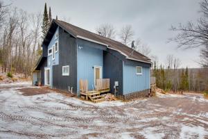 a blue building with snow on the ground at Iron River Condo with Gas Grill Near Skiing and Hiking in Iron River