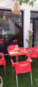 a red table and chairs in front of a store at BRIECH HOUSE in Asilah