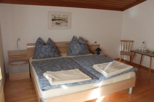 1 dormitorio con 1 cama con almohadas azules en Haus Hirschbichler, en Saalfelden am Steinernen Meer