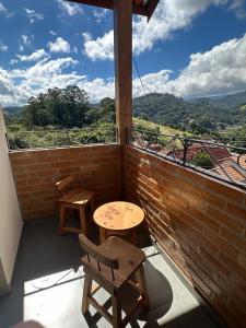 two tables and chairs on a balcony with a view at Studios Pinhal in Santo Antônio do Pinhal