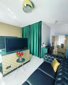 a living room with a couch and a flat screen tv at Apartments -Gold Glass Jacuzzi & Sauna Rynek Centrum -Parking -fakvat in Kielce +48 photos