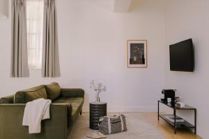 a living room with a green couch and a tv at Sonder Chelsea Green in London