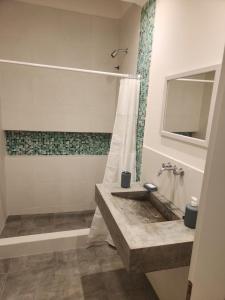a bathroom with a sink and a shower at Chacabuco Aparts in Chacabuco