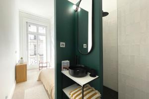 een badkamer met een groene muur met een wastafel en een douche bij l'Athéna - Standing - Hypercentre - 4pers in Rouen