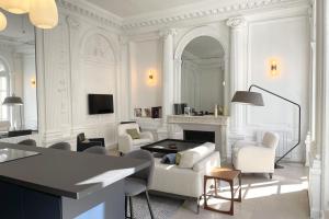 een woonkamer met witte meubels en een open haard bij l'Athéna - Standing - Hypercentre - 4pers in Rouen