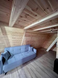 Sofá azul en una habitación con techo de madera en RoiA Chalet Fundata 1, en Fundata