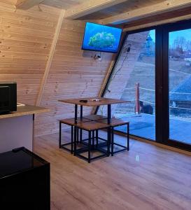 Zimmer mit einem Tisch und einem TV an der Wand in der Unterkunft RoiA Chalet Fundata 1 in Fundata