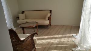 een woonkamer met een bank, een tafel en een stoel bij Beach Village in Dikili
