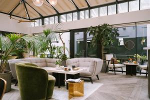 a lobby with couches and a table and plants at Sonder Chelsea Green in London