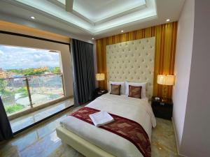 a bedroom with a large bed and a large window at Hotel Valentino in Noākhāli