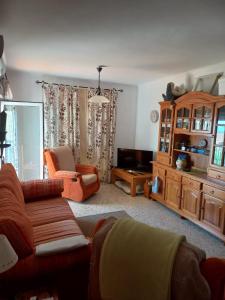 a living room with a couch and a chair at Beachfront 3 Bedroom Family Apartment in Matalascañas