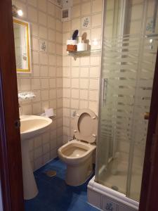 a bathroom with a toilet and a sink and a shower at Beachfront 3 Bedroom Family Apartment in Matalascañas