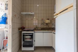 a small kitchen with white cabinets and an oven at Apto c otima localizacao em Gloria, Belo Horizonte in Belo Horizonte