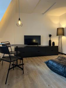 Studiowohnung 5 in Buxtehude في بوكستيهود: غرفة معيشة مع طاولة وتلفزيون وسرير