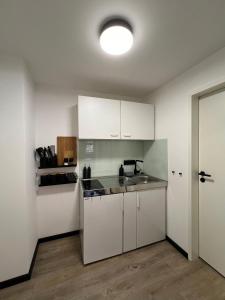 a kitchen with white cabinets and a sink at Studiowohnung 5 in Buxtehude in Buxtehude